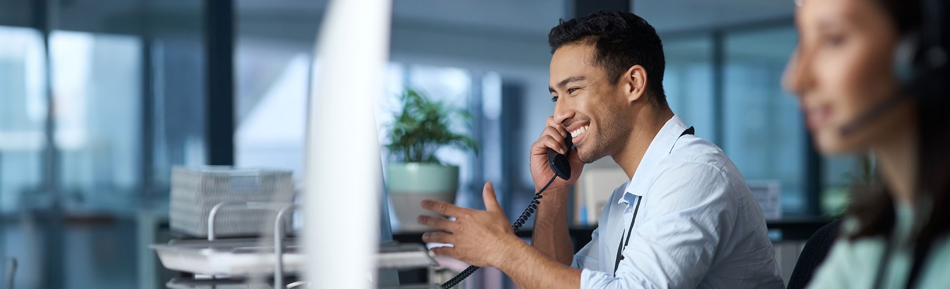 Lächelnder Mann telefoniert im Büro.