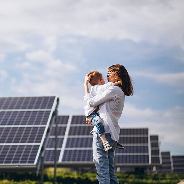Frau mit Kind vor Solaranlage