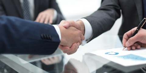 Geschäftspartner unterzeichnen Vertrag, Händedruck.