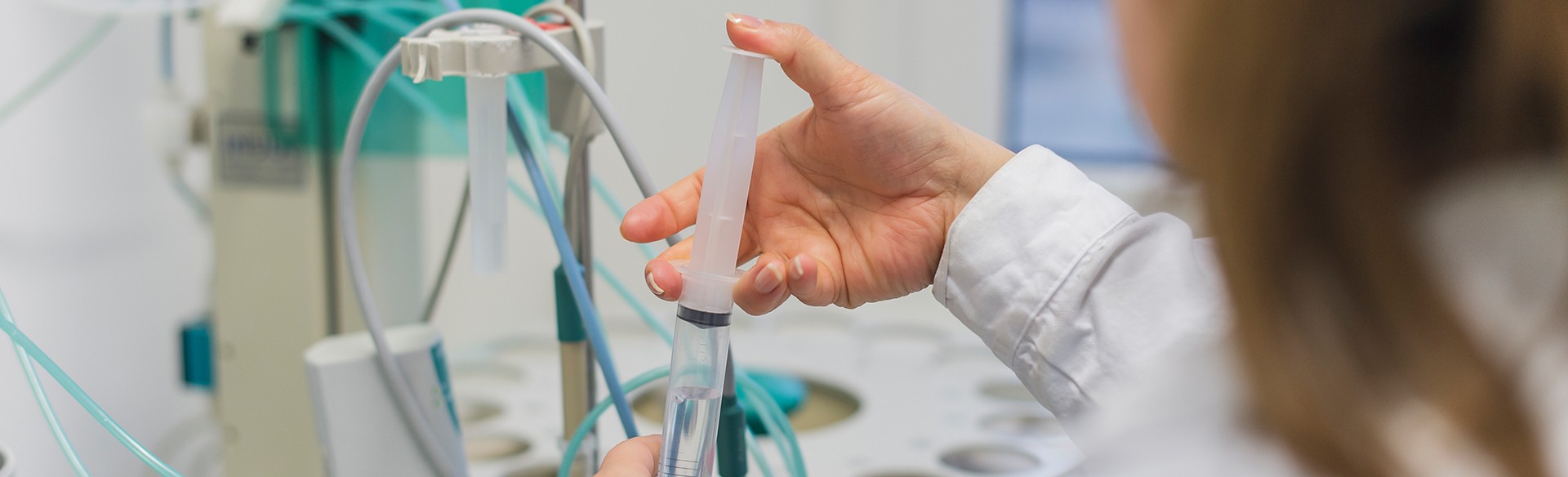 Hand hält Spritze mit Flüssigkeit. Medizinische Untersuchung.