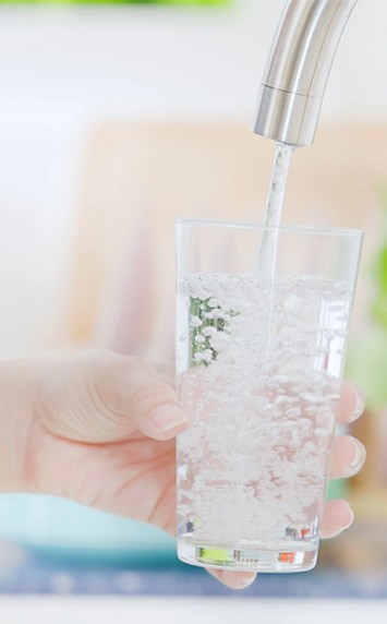 Glas wird mit Leitungswasser gefüllt.